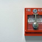 A close-up photo of a bright red fire alarm with space for text on the left
